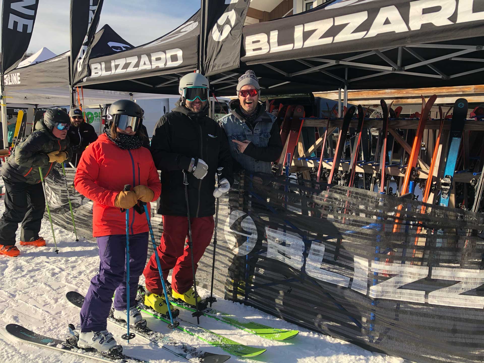 People smiling in front of Blizzard ski gear booth at a snow event