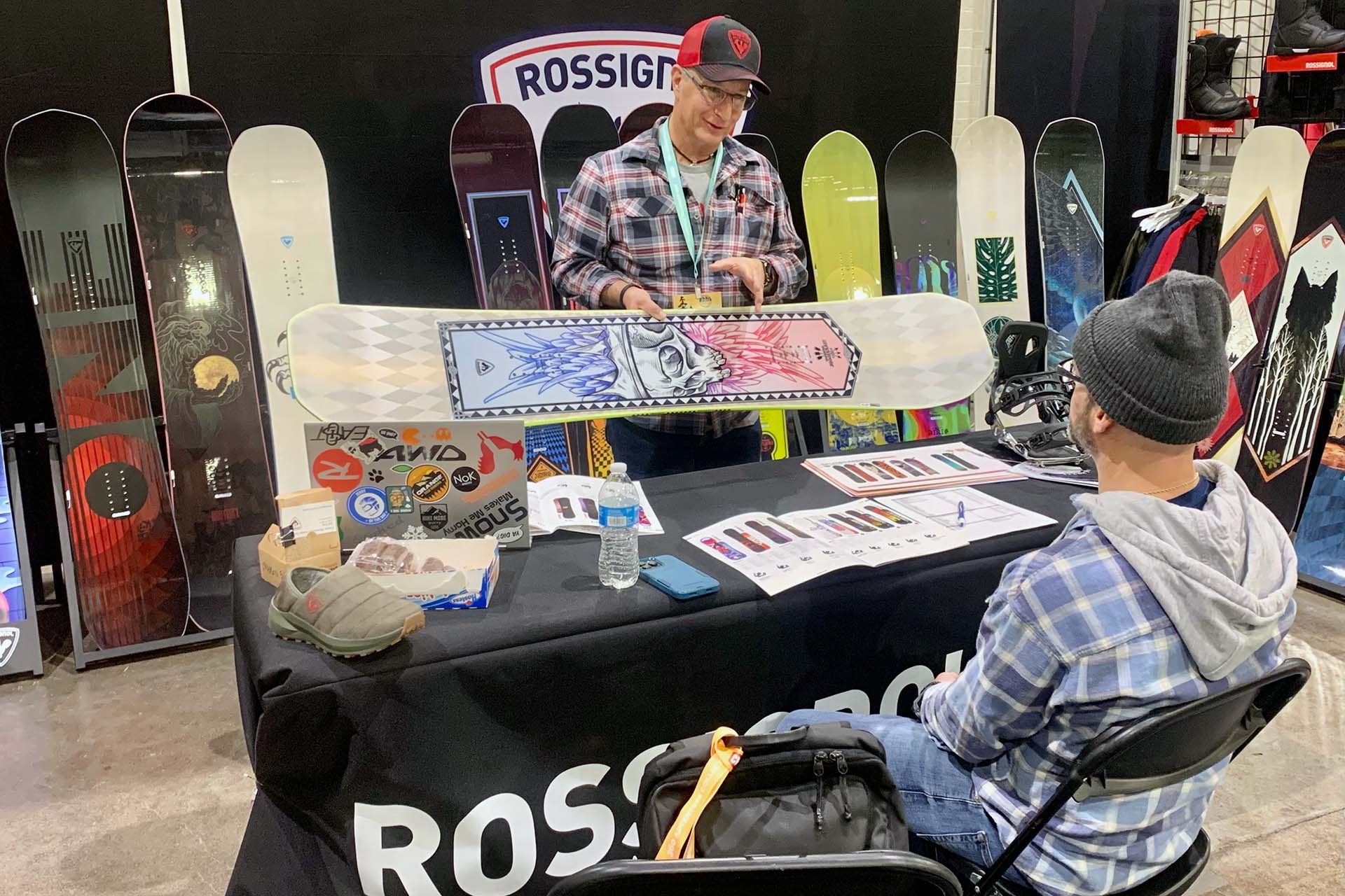 person displaying Rossignol snowboard at event
